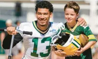  ?? MORRY GASH/AP ?? Allen Lazard, potentiall­y now the Packers’ No. 1 receiver, poses with a fan while riding a scooter to practice Saturday in Green Bay, Wisconsin.