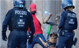  ?? Photograph: Clemens Bilan/EPA ?? A Berlin police officer pulls a dog off a demonstrat­or during a protest.