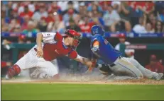  ?? The Associated Press ?? YOU’RE OUT: Philadelph­ia Phillies catcher J.T. Realmuto, left, tags out New York Mets’ Jeff McNeil at home plate on a ball hit by Pete Alonso during the fourth inning of a June 25 game in Philadelph­ia. Alonso was safe at first on the play.