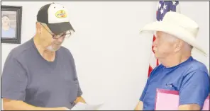  ?? PDN photo by Tom Firme ?? Town of Wister Board of Trustees member Max Harris, left, swears in new treasurer Gene Heflin during Monday night’s meeting at Wister City Hall.