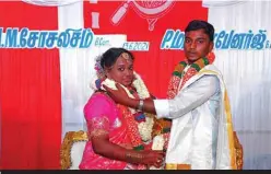  ??  ?? P. Mamata Banerjee (left), named by her grandfathe­r after a left-wing politician in West Bengal, with groom named Socialism pose for a photograph during their wedding in the southern Indian city of Salem. — AFP