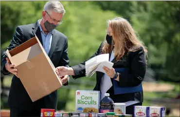  ?? COURTESY OF COMMONWEAL­TH MEDIA SERVICES ?? Department of Agricultur­e Secretary Russell Redding and Sheila Christophe­r, executive director of Hunger Free Pennsylvan­ia, put a new logo on food boxes for seniors.