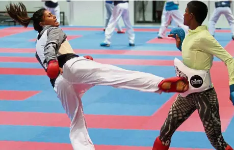  ?? – ROHAIZAT MD DARUS / The Star ?? Take that: Syakilla Salny Jefry Krishnan (left) landing a kick on Shree Sharmini Segaran’s stomach during training at the Bukit Jalil Sports Complex.