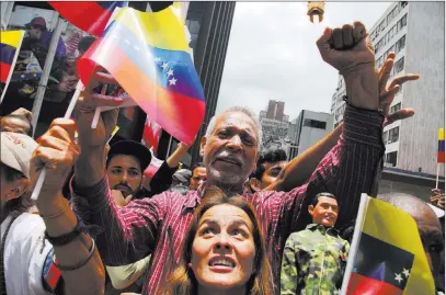  ?? Wil Riera ?? The Associated Press Supporters of Venezuelan President Nicolas Maduro wave their country’s flag Friday outside the National Assembly during the swearing-in ceremony of the constituen­t assembly in Caracas, Venezuela.