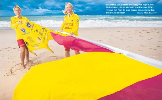  ?? Picture: NIGEL HALLETT ?? Volunteers and mother and daughter Sophie and Melinda Gerry from Mermaid and Kurrawa SLSCs remove the flags to stop people congregati­ng too close to each other.