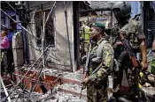  ?? PRADEEP PATHIRAN / ASSOCIATED PRESS ?? A Sri Lankan police officer stands near a vandalized building Tuesday in Digana, a suburb of the city of Kandy. The area was under curfew after Buddhist mobs burned Muslim-owned shops.