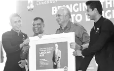  ??  ?? Fernandes (second from left) presenting a souvenir to Najib in Langkawi during the launch of AirAsia’s LangkawiSh­enzen flight.