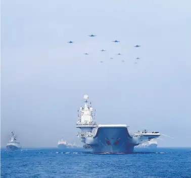  ?? REUTERS / STRINGER ?? Warships and jets of the Chinese People’s Liberation Army Navy take part in a military display in the South China Sea in 2018. The continued thawing of the Northwest Passage could see an increased Chinese presence in Canadian waters.