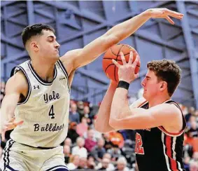  ?? Noah K. Murray/Associated Press ?? Yale’s John Poulakidas (4) defends against Princeton forward Caden Pierce (12) during the first half of the Ivy League championsh­ip on Sunday.