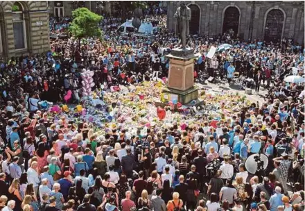  ?? AP PIC ?? Members of the public observing a minute of silence in memory of the victims of Monday’s explosion at St Ann’s Square in Manchester, England, yesterday.