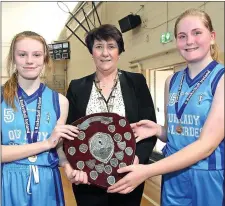  ??  ?? Joint captains Kirsten Kenny and Sinéad Curran receiving the shield from Theresa Walsh, President of Basketball Ireland.