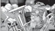  ?? AP/The Florida Times-Union/BRUCE LIPSKY ?? Scott Horner wears an elf-eared stocking hat while playing the euphonium during the 23rd annual Tuba Christmas, held Saturday at the Jacksonvil­le Landing in Jacksonvil­le, Fla.