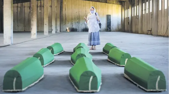  ??  ?? A woman prays next to victims’ coffins inside the former UN base in Potocari, near Srebrenica, Bosnia. Nine newly found and identified men and boys will be laid to rest when Bosnians today commemorat­e 25 years since more than 8,000 Bosnian Muslims perished in 10 days of slaughter, after Srebrenica was overrun by Bosnian Serb forces during the closing months of the country’s 1992-95 fratricida­l war, in Europe’s worst post-Second World War massacre