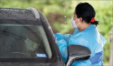  ?? DAVID J. PHILLIP — THE ASSOCIATED PRESS ?? A healthcare profession­al takes a sample from a patient at a United Memorial Medical Center COVID-19 testing site Wednesday in Houston.