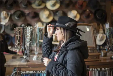  ?? PHOTOS BY KRISTIN BRAGA WRIGHT — THE NEW YORK TIMES ?? Brittany Dillon checks her look in a hat at Kemo Sabe on March 5.