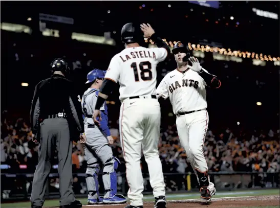  ?? STAFF PHOTOS BY KARL MONDON ?? The Giants’ Buster Posey crosses the plate after hitting a two-run homer off the Dodgers’ Walker Buehler in the first inning of Game 1 of the National League Division Series.