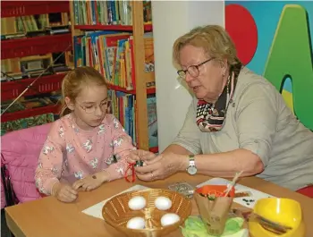  ?? CHRISTINE BOSE ?? Die sieben Jahre alte Franziska Fromm aus Dingelstäd­t holte sich von Monika Dölle, Leiterin der Kreativgru­ppe in der Unstrut-Stadt, Tipps für das Eier-Verzieren.