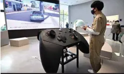  ??  ?? In this file photo a staff member plays a game in front of an oversized mock-up of Microsoft’s Xbox controller at a flagship store of SK Telecom in Seoul . — AFP