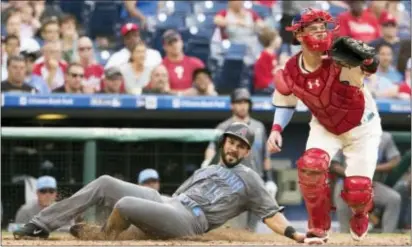  ?? CHRIS SZAGOLA — THE ASSOCIATED PRESS ?? Arizona’s Reymond Fuentes, left, slides in to score on a single by Daniel Descalso as Phillies catcher Andrew Knapp, right, looks for the ball during the seventh inning Saturday in Philadelph­ia.