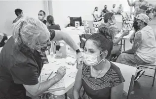  ?? Matthew Busch / New York Times ?? Raquel Gonzales, 27, receives a COVID-19 shot during a free vaccinatio­n clinic in San Antonio. Some 2.6 million Texans have gotten their booster, according to state health numbers.