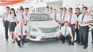  ??  ?? KUNJUNGI KAMI: Ketua Cawangan Bilik Pameran ETCM Kuching 3S Chen Chee Kian (berdiri, dua kanan) merakam kenangan bersama kakitangan­nya dan Nissan Teana baharu.