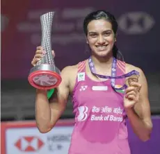  ?? — AFP ?? Winner Sindhu Pusarla of India poses with her trophy after the women’s singles final at the 2018 BWF World Tour Finals in Guangzhou, southern China’s Guangdong province.