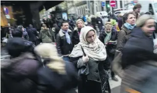  ?? Fred Dufour / AFP Photo ?? A woman wearing a scarf crosses the street in central Paris. A ruling by the European Court of Justice has reopened the media debate about the hijab