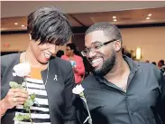  ??  ?? Sagicor’s Chad Anthony Smart has more than a few laughs for Michelle Distant as he hands her a flower and an arm candy gift to celebrate the fight against cancer.