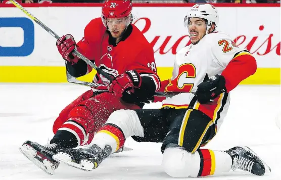  ?? KARL B DEBLAKER/THE ASSOCIATED PRESS ?? Elias Lindholm, left, formerly of the Hurricanes, and Travis Hamonic were opponents last season. Now they look to create a bond in Flames red.