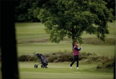  ?? MATT DUNHAM ?? A golfer hits a shot after Sunningdal­e Golf Club reopened this morning as part of the British government relaxing the coronaviru­s lockdown measures, in Sunningdal­e, England, Wednesday, May 13, 2020. Tennis courts and golf courses in England can reopen from Wednesday, the sports venues were ordered to be closed in March when Britain imposed a national lockdown due to the coronaviru­s outbreak.