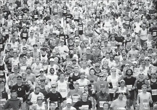  ?? ANTONIO PEREZ/TNS ?? Marathoner­s make their way down Grand Avenue near Michigan Avenue during the Chicago Marathon on Sunday.