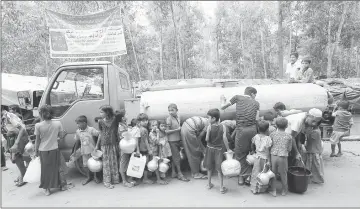  ??  ?? Rohingya refugees carry their containers as they wait to fill them up with drinking water from a tanker at Kutupalong refugee camp near Cox’s Bazar, Bangladesh.— Reuters photo