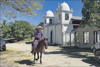  ?? ?? THE EXODUS among Salvadoran­s due to poverty, failing farms and war left many broken households in its wake. Above, a rider on horseback traverses the dusty roads of San Pedro, El Salvador.