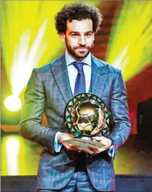  ?? SEYLLOU/AFP ?? Liverpool’s Egyptian forward Mohamed Salah poses with the 2018 African Footballer of the Year Award during an award ceremony in Dakar on Tuesday.