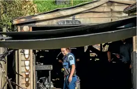  ?? PHOTO: BRADEN FASTIER / FAIRFAX NZ ?? Police and Fire Investigat­ors inspect the scene of a fire in a Toi Toi garage that happened in the early hours of Thursday morning.