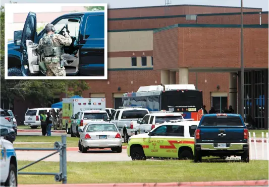  ?? PHOTOS AFP ?? Des ambulancie­rs et des policiers, dont des agents du FBI, se sont regroupés hier dans le stationnem­ent de cette école de Santa Fe.