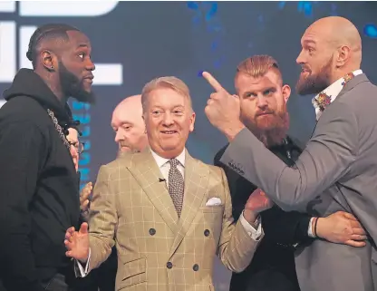  ?? Picture: Getty. ?? Deontay Wilder, left, and Tyson Fury being kept apart by boxing promoter Frank Warren during a press conference ahead of their fight in December.