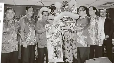  ??  ?? 也是房屋及城市化部部­長的阿邦佐哈里（右三），去年在房屋部華人新年­慶祝活動上，接收瑞獅呈上的賀歲品。