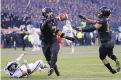  ?? MATT SLOCUM/ASSOCIATED PRESS ?? Army’s Jaylon McClinton, center, intercepts a pass tipped by teammate Mike Reynolds, right, that was intended for Navy’s Mychal Cooper.