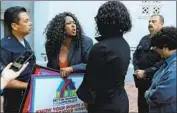  ??  ?? CANDICE GRAHAM, center, who works with property owners, and Samantha Granberry of Healthy Housing Foundation have words outside City Hall.