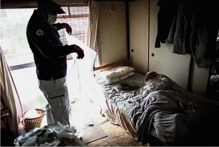  ?? — AFP ?? Alone in death: This picture taken in June shows cleaner Ohshima collecting a mattress soaked with bodily fluids of a man who died alone and undiscover­ed for weeks in his apartment in Yokohama.