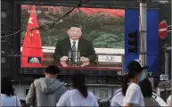  ??  ?? Beijing residents watch as Xi addresses the WHO