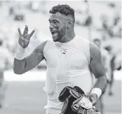  ?? AL DIAZ adiaz@miamiheral­d.com ?? Dolphins quarterbac­k Tua Tagovailoa, holding up four fingers for four wins in a row, has elevated his play.