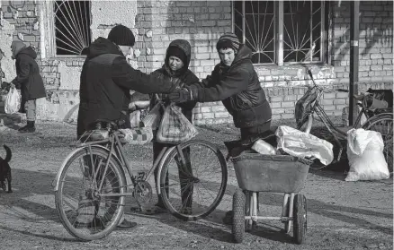  ?? Andriy Andriyenko/associated Press ?? Local resident receive food Friday at a mobile humanitari­an aid position in the village of Zarichne, in Ukraine’s Donetsk region. An official working with the U.N. Human Rights Council says civilians “require immediate attention.”