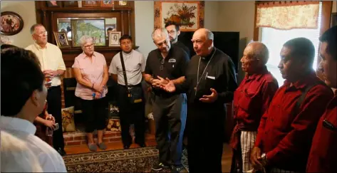  ?? AP PHOTO/SUE OGROCKI ?? Guatemalan Bishop Julio Edgar Cabrera, center, leads a prayer in the Rother Family home in Okarche, Okla, on Thursday. Father Stanley Rother was an American priest killed during Guatemala’s civil war, who is on the path to possible sainthood.