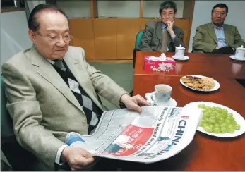  ?? EDMOND TANG / CHINA DAILY ?? Louis Cha reads China Daily while visiting the newspaper’s Hong Kong office in 2005.