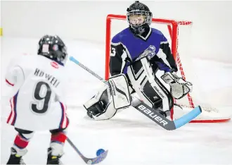  ?? AL CHAREST ?? Northwest Warriors’ Christophe­r Howell takes a shot on Benjamin Degenhardt of the Lake Bonavista Breakers during the opening of Esso Minor Hockey Week on Saturday at Flames Community Arena.