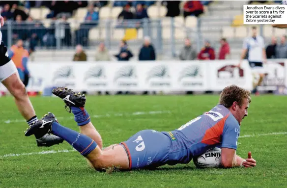  ??  ?? Jonathan Evans dives over to score a try for the Scarlets against Zebre yesterday