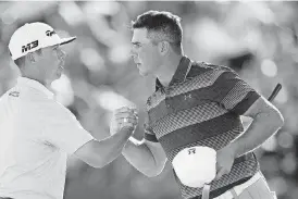  ?? [AP PHOTO] ?? After winning a one-hole playoff, Gary Woodland, right, shakes hands with Chez Reavie on the 18th green during the final round of the Waste Management Phoenix Open Sunday in Scottsdale, Ariz.