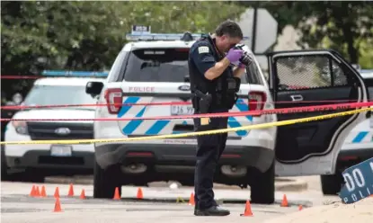  ?? ASHLEE REZIN GARCIA/SUN-TIMES ?? Police investigat­e at the 25th District station, 5555 W. Grand Ave., after multiple officers were shot Thursday outside the station. The suspect also was shot multiple times in the incident.